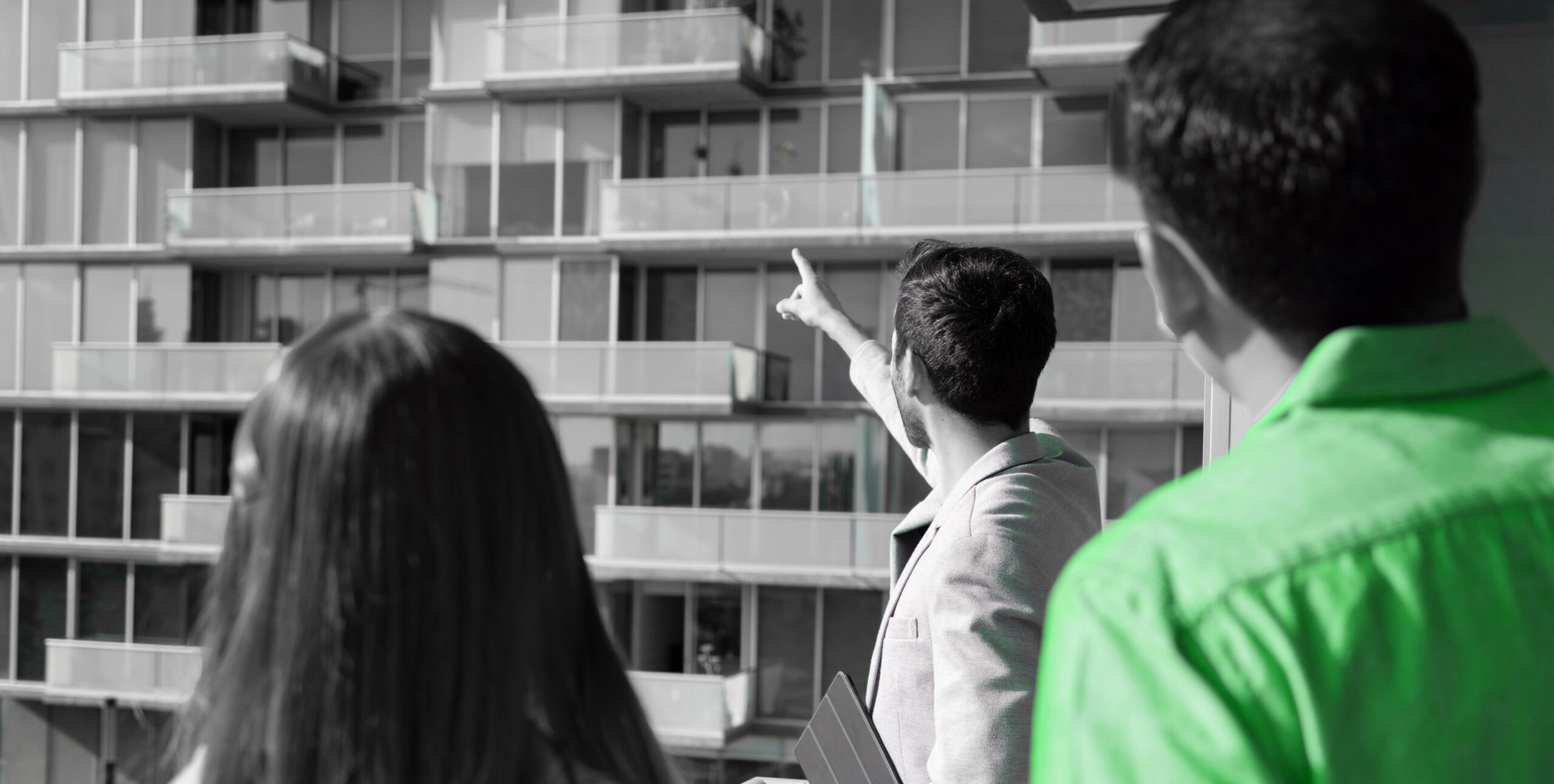 Real estate agent touring apartment balconies with clients