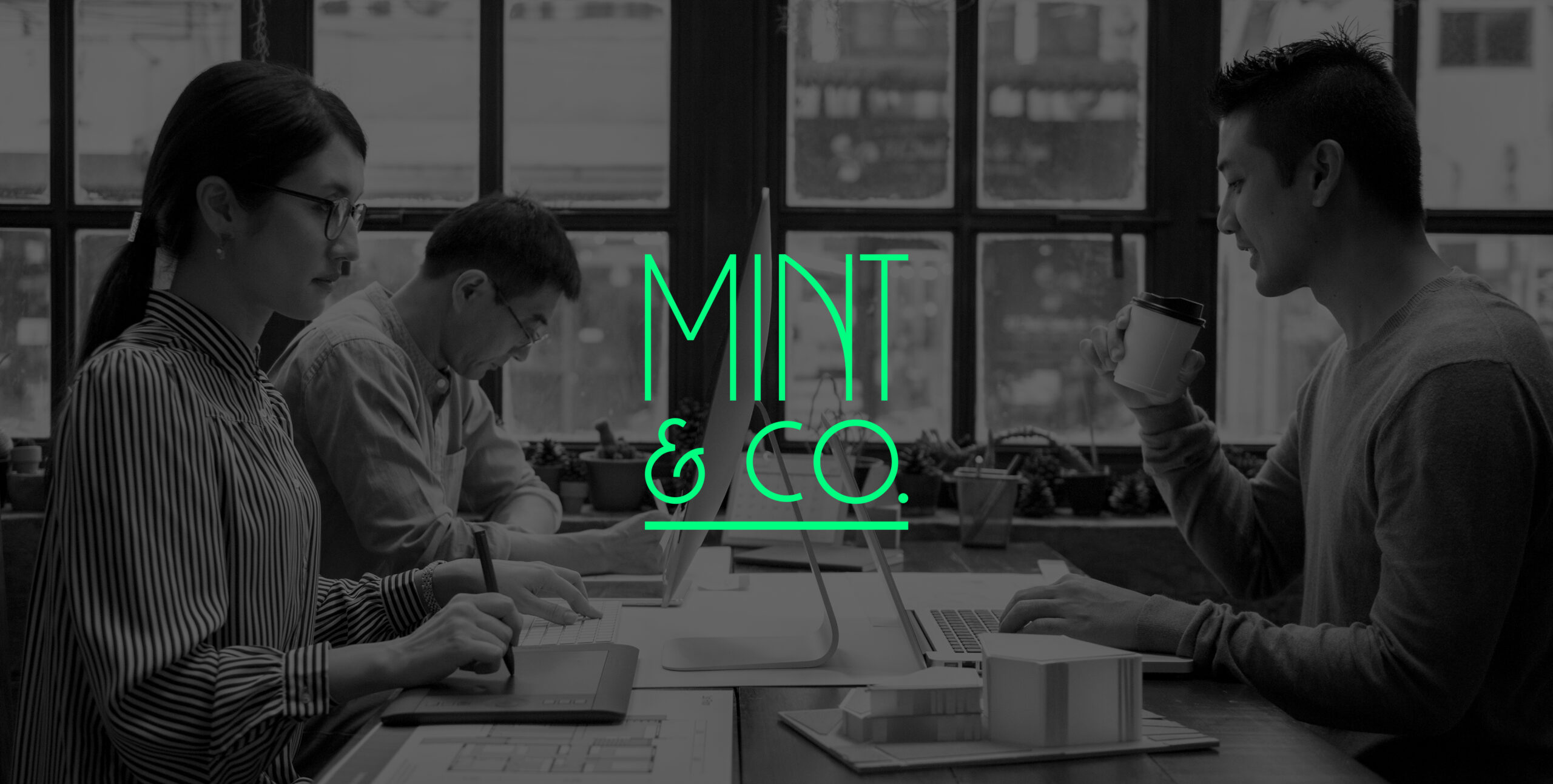 Mint & Co. creative team working at a shared desk
