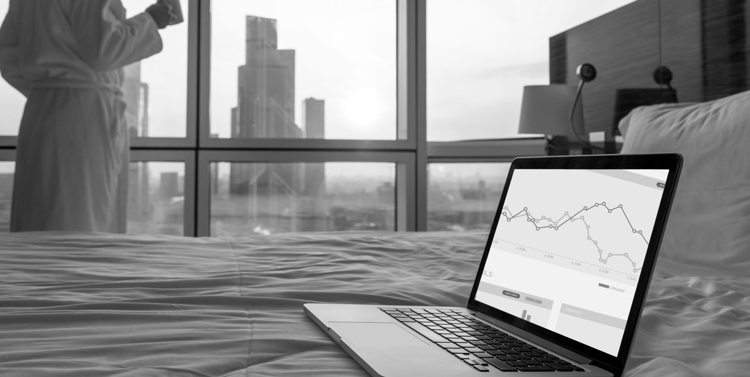 Laptop showing organic traffic dashboard over Dubai skyline, AI real estate analytics