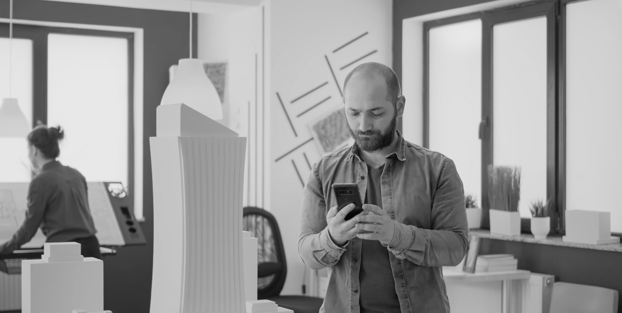 Architect with a 3D-printed building model, AI-assisted real estate modeling
