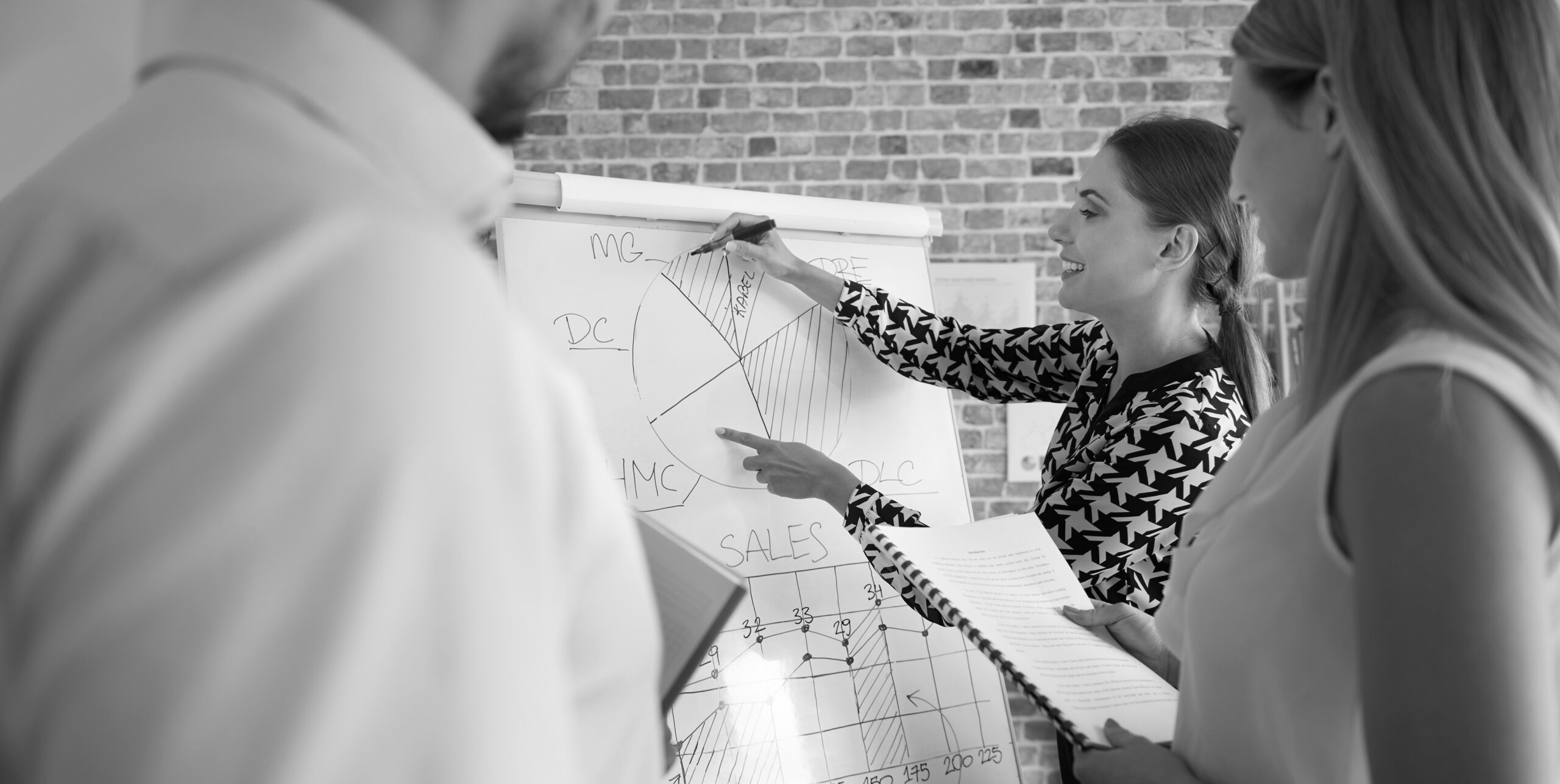 Marketing team reviewing sales figures on a flip chart