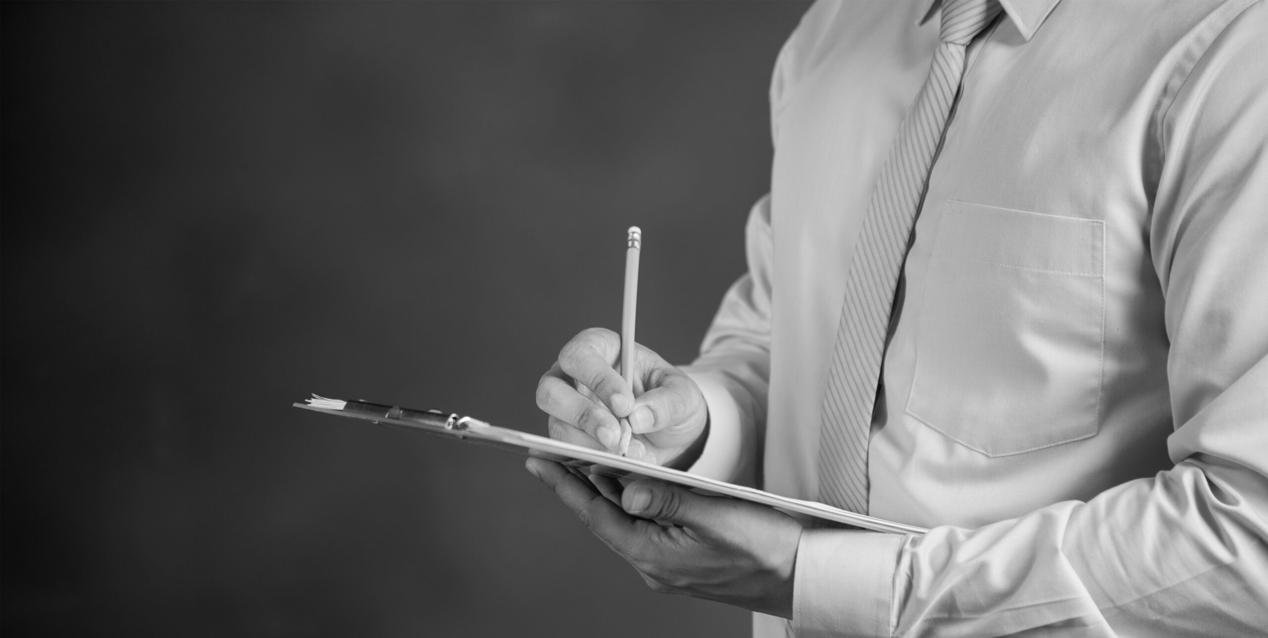 Man writing on a clipboard, real estate site inspection checklist