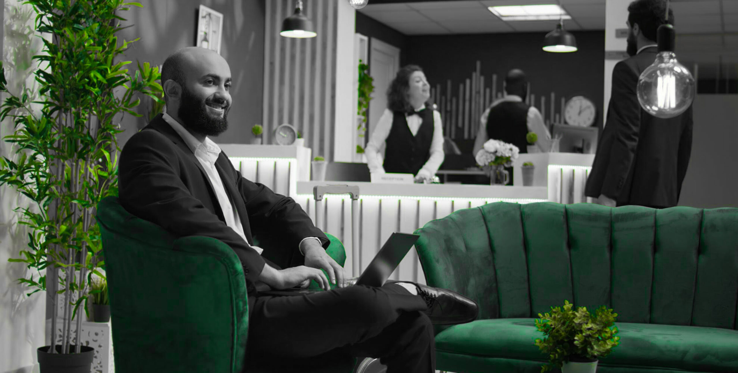 Businessman working on a laptop in a hotel lobby armchair