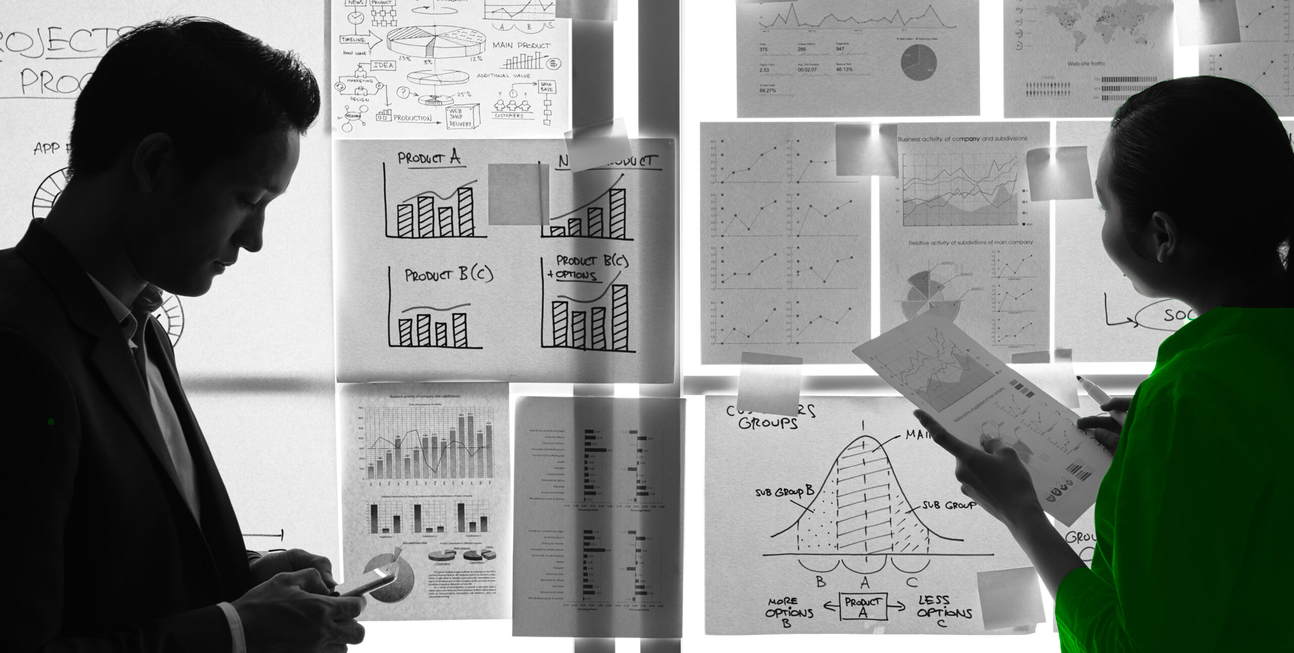 Colleagues reviewing charts on a glass wall, real estate marketing planning