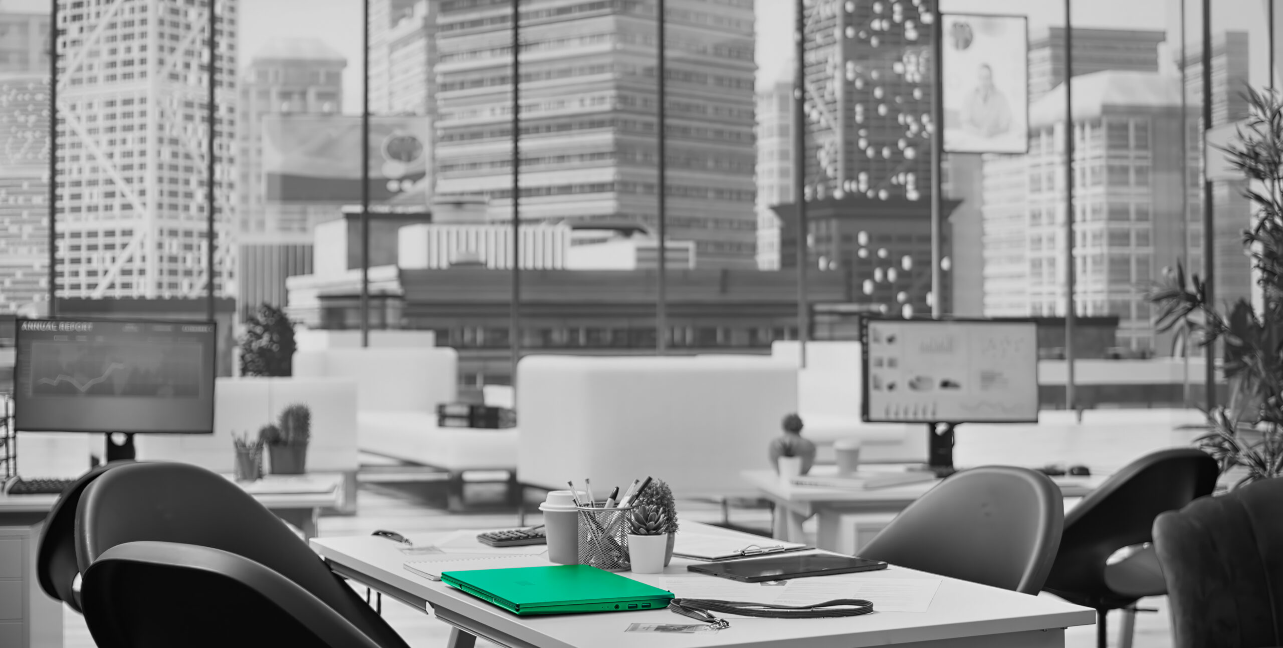 Desk with laptop overlooking a city skyline, real estate performance dashboards