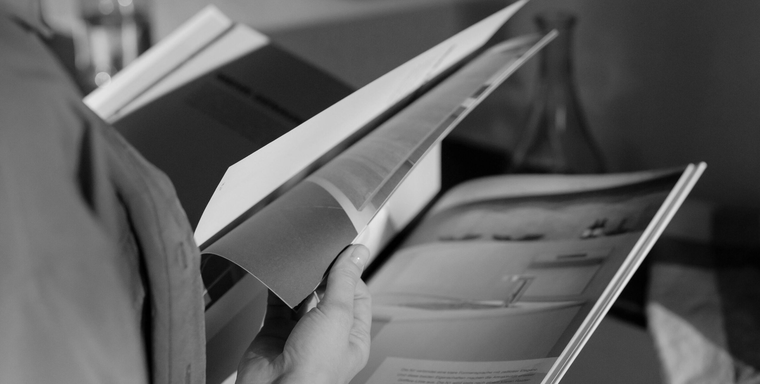 Hands flipping through a printed real estate brochure