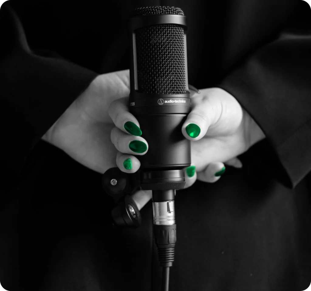 Hands holding a podcast microphone, audio content marketing for real estate